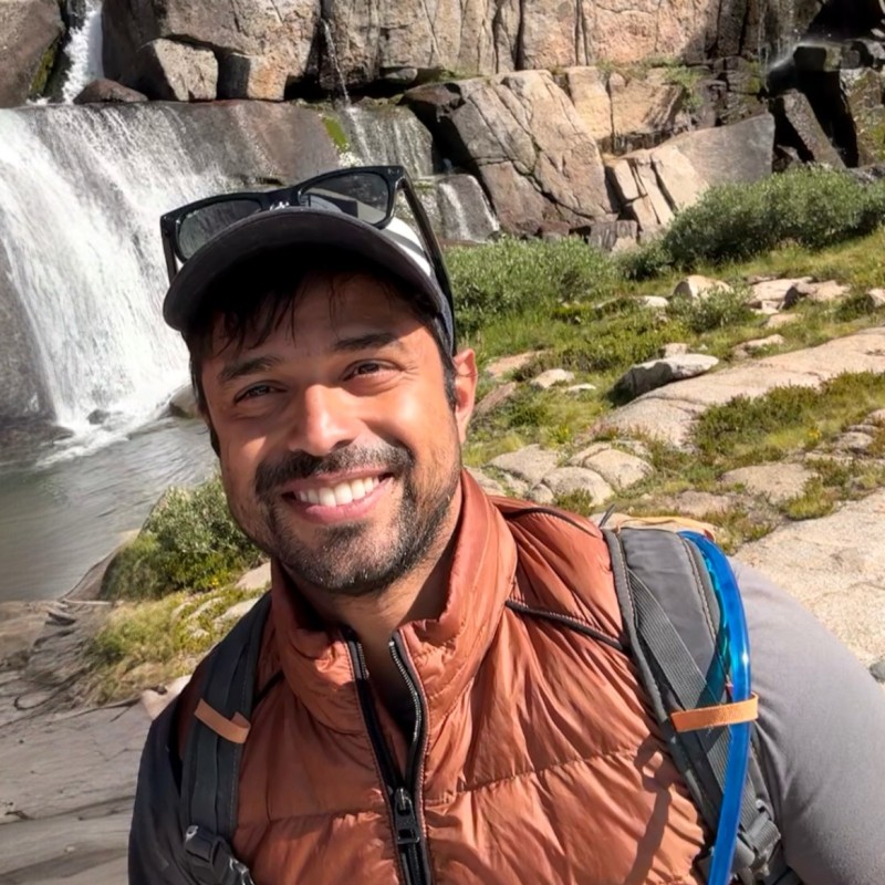 Raunaq Naidu hiking beside a waterfall